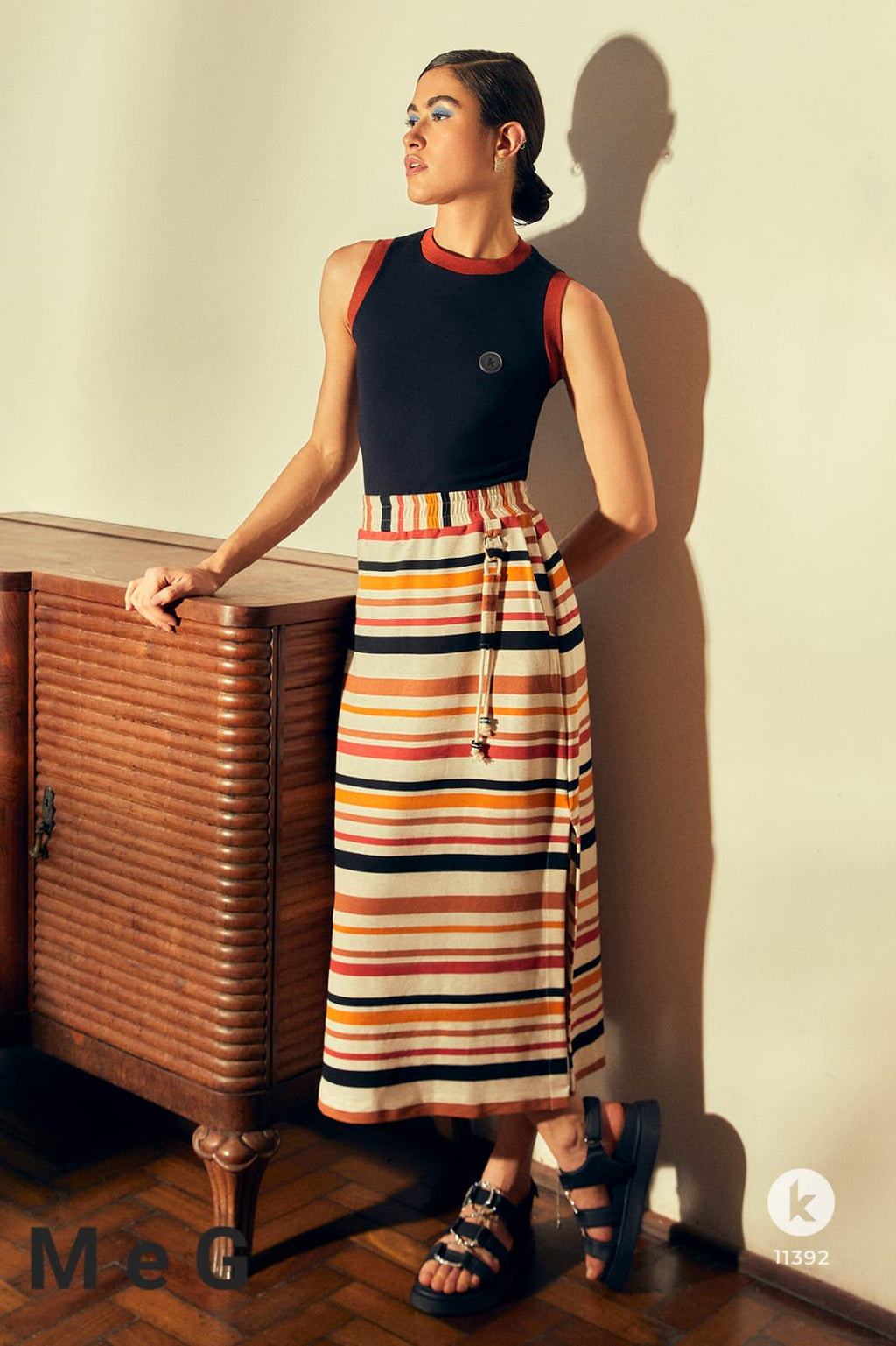 Conjunto de saia listrada de laranja e preto e blusa malha preta